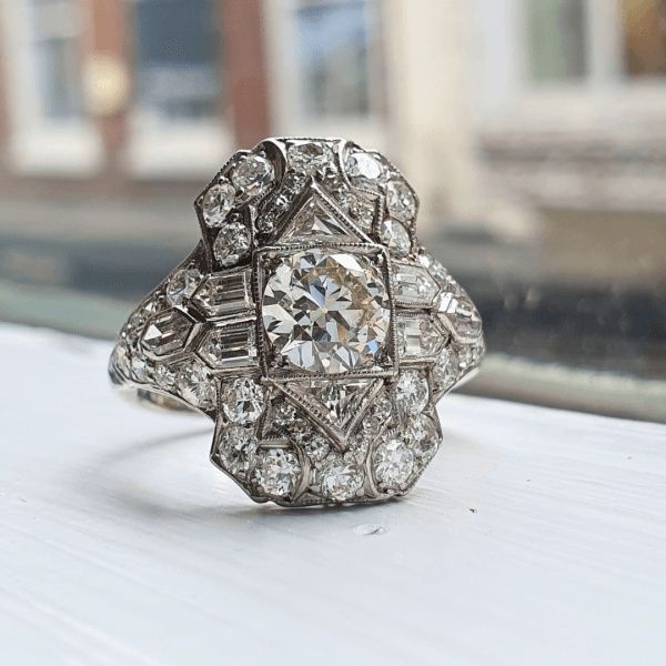 Närbild av en diamantprydd ring med geometriska Art Déco-former